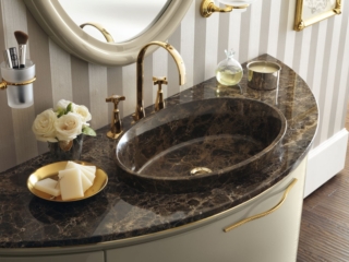 Il piano in marmo Emperador per lavabo ovale in appoggio nella stessa finitura completa il mobile sospeso della collezione Magnifica di Scavolini laccato lucido Tortora con ante curve. Prezzo su richiesta. www.scavolini.com