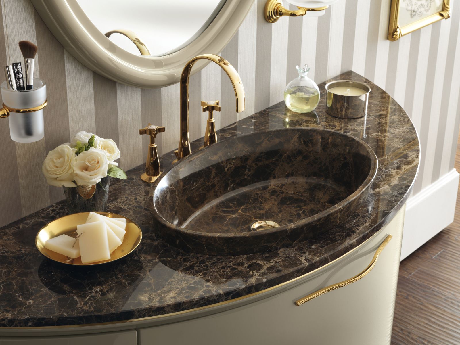 Il piano in marmo Emperador per lavabo ovale in appoggio nella stessa finitura completa il mobile sospeso della collezione Magnifica di Scavolini laccato lucido Tortora con ante curve. Prezzo su richiesta. www.scavolini.com