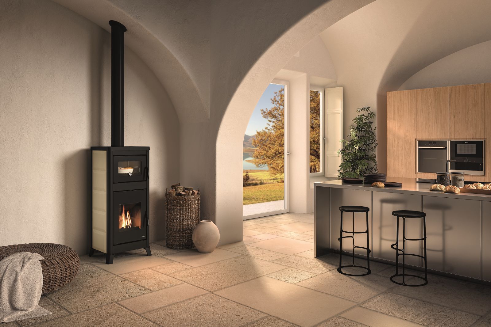 È dotata di forno in acciaio per la cottura dei cibi con termometro la stufa a legna Dorotea di Palazzetti dal design tradizionale con top in ghisa e rivestimento disponibile in ghisa, ceramica o metallo con funzionamento ad aria irraggiamento. In classe di efficienza energetica A+. Il forno misura L 35 x P 36 x 23 cm. La stufa completa di forno misura L 57 x P 54 x H 153 cm. Prezzo 4.040 euro. https://palazzetti.it/