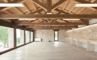 L'intervento di recupero di Case Marian ha rispettato la struttura esistente utilizzando materiali naturali come il legno. In foto è la luminosa sala conferenze.