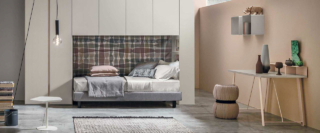 Nella composizione 08A di Tomasella l'armadio a ponte con le ante a battente in una colorazione chiara incornicia il letto Sommier lasciando libero lo spazio al centro della camera. L'armadio misura L 335,5 x P 62 x H 255 cm. Prezzo su progetto. https://www.tomasella.it