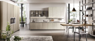 Si sviluppa su due pareti la composizione Mirage 3 di Moretti Compact Cucine: da un lato le basi in melaminico Frassino Cenere con i pensili verticali in malta nebbia texture Rose e vetro fumé, dall'altro l'armadiatura a colonne che include gli elettrodomestici e la dispensa. Un modulo base da 60 cm con anta battente, prezzo 350 euro (esclusi top e zoccolo). https://cucine.moretticompact.it