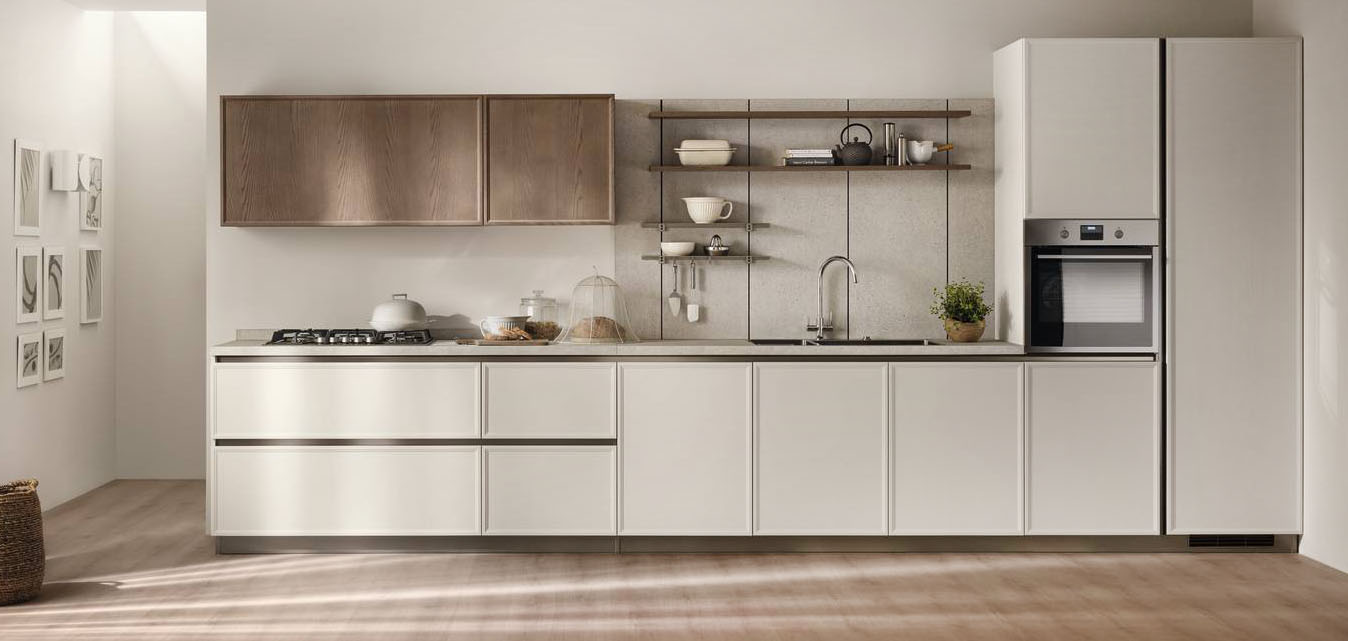 La cucina lineare Poetica di Scavolini è composta da basi e colonne dotate di ante telaio in legno di Frassino Riso e da pensili con ante in legno di Frassino Pecan; le gole e gli zoccoli nella finitura Titanio scandiscono la composizione. La boiserie Vertical System in laminato Street Beige è dotata di mensole in Frassino Pecan; il piano cucina è in laminato Street Beige. Prezzo su richiesta. https://www.scavolini.com