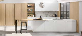 La venatura del Noce Eucalipto impreziosisce le ante delle basi e dei pensili nella cucina Metropolis di Stosa; le colonne e i pensili a sviluppo orizzontale hanno le ante in Pet Cachemere opaco che danno vita ad un raffinato contrasto. Il top è realizzato in pietra Neolith Calacatta Silk; le grandi maniglie godronate sono in metallo nella finitura Bronzo come le gambe del tavolo con il piano in fenix Cacao Orinoco. Un modulo base da 60 cm, prezzo a partire da 189 euro + Iva. https://www.stosacucine.com