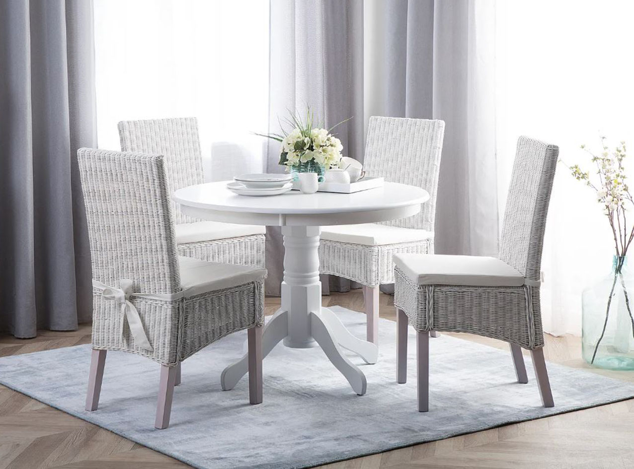 Il tavolo Akron ha il piano rotondo in resistente MDF e un basamento  centrale in legno verniciato bianco che ne sottolinea lo stile rétro. Misura Ø 100 x H 76 cm. Prezzo 249 euro. Intorno trovano posto le sedie Andes con lo schienale alto in rattan bianco intrecciato a mano. Misurano L 46 x P 50 x H 96 cm. Prezzo 379 euro (per il set da 2 pezzi). Tutto di Beliani. www.beliani.it