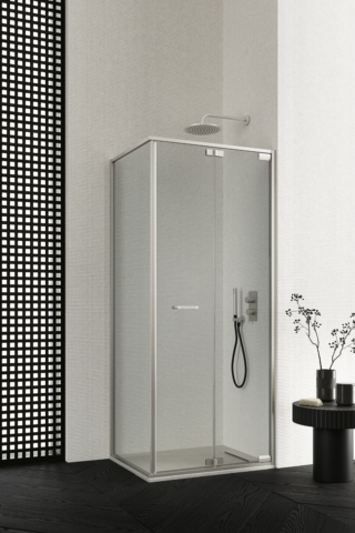 Box doccia Zefiro, configurazione ad angolo con porta pieghevole e laterale; profili e dettagli in Inox e vetro in finitura trasparente 6 mm. In abbinamento, piatto doccia Mark in Tekno Gelcoat Bianco da L 90 x P 70 cm.