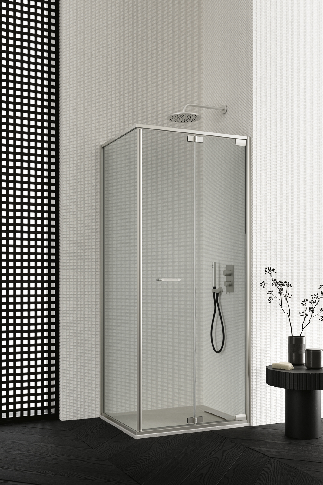 Box doccia Zefiro, configurazione ad angolo con porta pieghevole e laterale; profili e dettagli in Inox e vetro in finitura trasparente 6 mm. In abbinamento, piatto doccia Mark in Tekno Gelcoat Bianco da L 90 x P 70 cm.