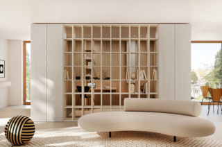 La libreria passante diventa un filtro visivo leggero tra studio e zona giorno, mantenendo aperta la percezione dello spazio.