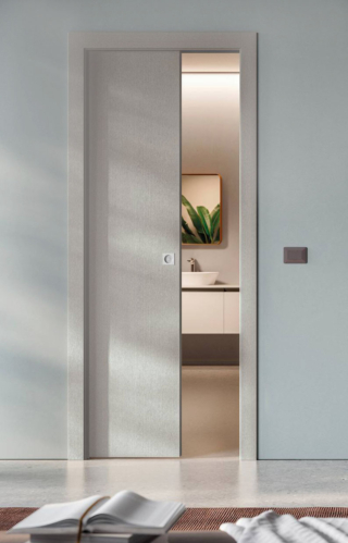 La porta scorrevole a scomparsa della linea Textile di Bertolotto è caratterizzata da un’estetica ispirata alla trama dei tessuti con tre finiture, Alma, Basalto e Duna, con un diverso gioco di tonalità e profondità. La superficie, caratterizzata da un effetto tramato estremamente dinamico e tridimensionale, crea un'illusione ottica che avvolge gli spazi con un tocco di morbidezza e calore. In foto in finitura Basalto effetto legno, misure e prezzo a preventivo. www.bertolotto.com