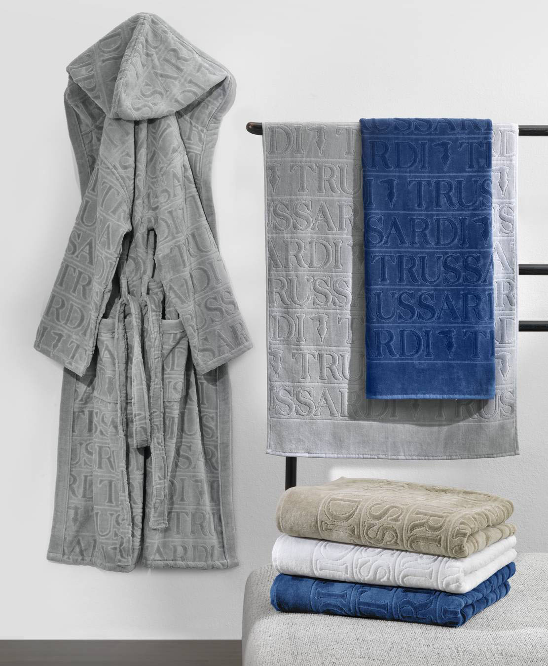 Hanno la superficie decorata da un motivo lettering in rilievo i teli da bagno e l'accappatoio coordinato Overlogo di Trussardi Casa by Mirabello Carrara. Sono tutti prodotti in morbida spugna in 100% cotone. Prezzo a partire da 161 euro per l’accappatoio e da 58,5 euro per il telo. https://mirabellocarrara.it