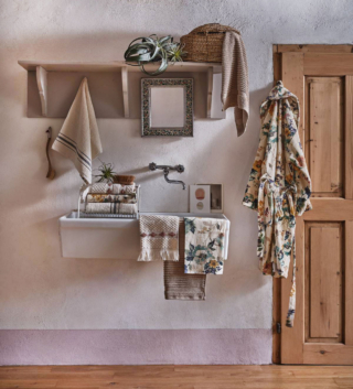 Ispirazione country per l'accappatoio in velour di puro cotone beige con una stampa floreale di ispirazione retrò. Prezzo 79,90 euro. L'asciugamano coordinato misura L 40 x P 60 cm. Prezzo a partire da 9,90 euro. L'asciugamano in spugna di cotone beige ha il bordo decorato con un motivo a piccoli rombi marroni frange sottili. Misura L 40 x P 60 cm. Prezzo da 8,90 euro. Tutto di Coincasa. https://www.coin.it