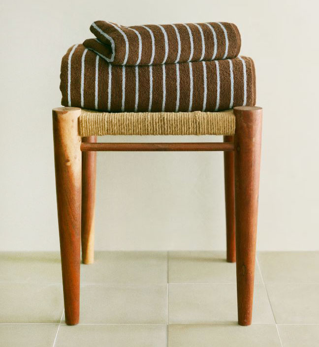 Sottili righe azzurre su fondo marrone per l'asciugamano di H&M Home, in morbida spugna assorbente, che può essere abbinato ad altri asciugamani tinta unita. È presente un comodo passante per appenderlo. Misura L 50 x P 70 cm. Prezzo 5,99 euro. https://www2.hm.com