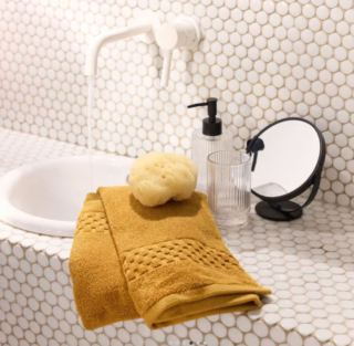 Giallo senape per l'asciugamano da bagno in cotone biologico di Maisons du Monde che ha il bordo decorato da un motivo a scacchiera. La colorazione, calda e intensa, permette di “rinnovare” il bagno. Misura L 70 x P 140 cm. Prezzo 17,99 euro. https://www.maisonsdumonde.com