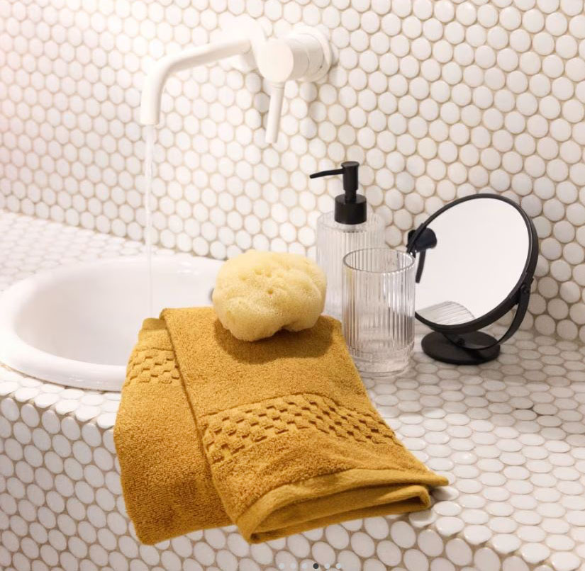 Giallo senape per l'asciugamano da bagno in cotone biologico di Maisons du Monde che ha il bordo decorato da un motivo a scacchiera. La colorazione, calda e intensa, permette di “rinnovare” il bagno. Misura L 70 x P 140 cm. Prezzo 17,99 euro. https://www.maisonsdumonde.com