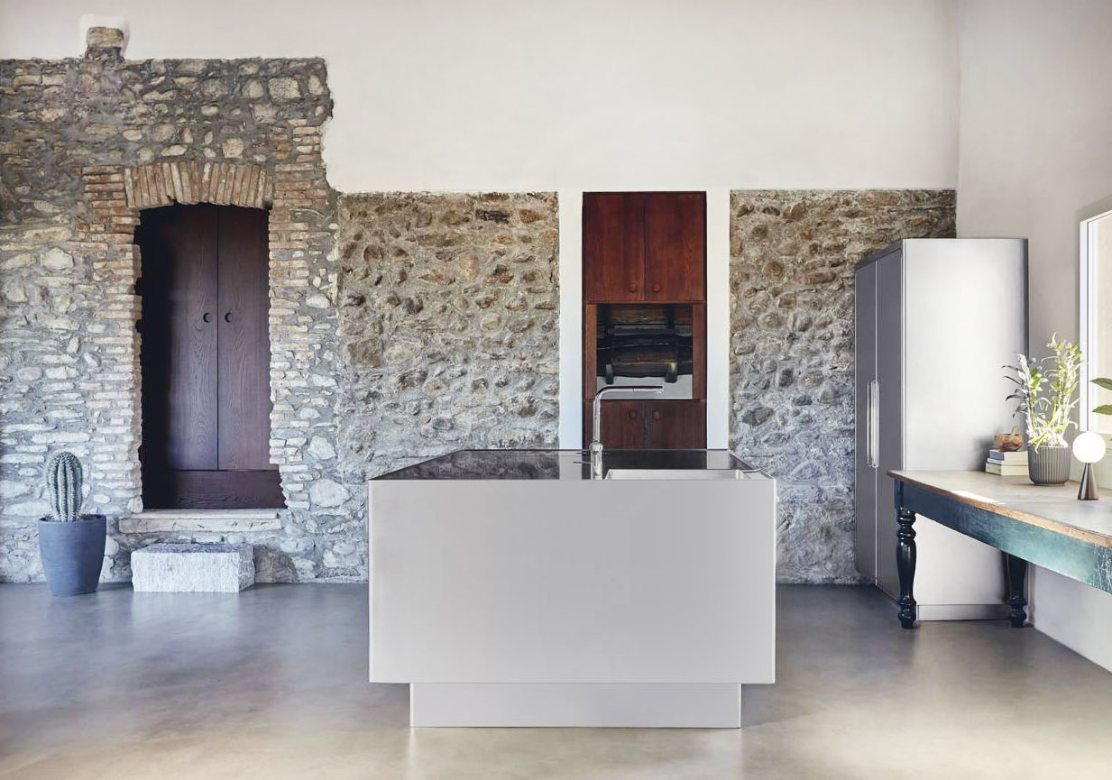 L'isola centrale della cucina Ego di Abimis ha una forma compatta e squadrata che ne sottolinea lo stile moderno; è realizzata in acciaio AISI 304 con finitura orbitata a mano che rende la superficie “calda” e opaca, resistente a impronte e graffi. Le ante delle basi raggiate sono coordinate con quelle della colonna a parete che contiene frigorifero e congelatore. Il top privo di fughe accoglie sia la zona cottura sia quella lavaggio. Prezzo su progetto. https://abimis.com