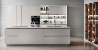 Le ante piane in Laccato Opaco Bianco Puro sottolineano lo stile essenziale della composizione Oyster di Veneta Cucine che è composta da un' isola attrezzata, con un lavello in acciaio inox e un piano cottura a induzione, e la grande armadiatura a colonne. Il top in Caranto Ker Calacatta Statuario Opaco e la boiserie StepSystem con schienale vetro luminoso completano la composizione. Un modulo base da 60 cm, prezzo a partire da 349 euro. https://www.venetacucine.com