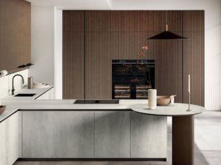 La cucina Glass 2.0 di Arredo3 è caratterizzata dalla presenza di una penisola centrale dotata di un piccolo piano snack rotondo, coordinato con il top. Le ante delle basi, lisce effetto pietra grigia, sono disponibili realizzate in HPL e in Laminam; quelle delle colonne nella finitura legno scuro come il gambone di sostegno del piano snack. Prezzo su richiesta. https://www.arredo3.com