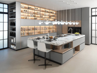 La grande isola della cucina R1.90 Clear-R3.90Wind Mate di Porcelanosa ha il piano di lavoro in ceramica di grande formato Xtone Invisible White con finitura Nature che si estende per dare vita ad un piccolo bancone snack a sbalzo. Prezzo su richiesta. https://www.porcelanosa.com/it