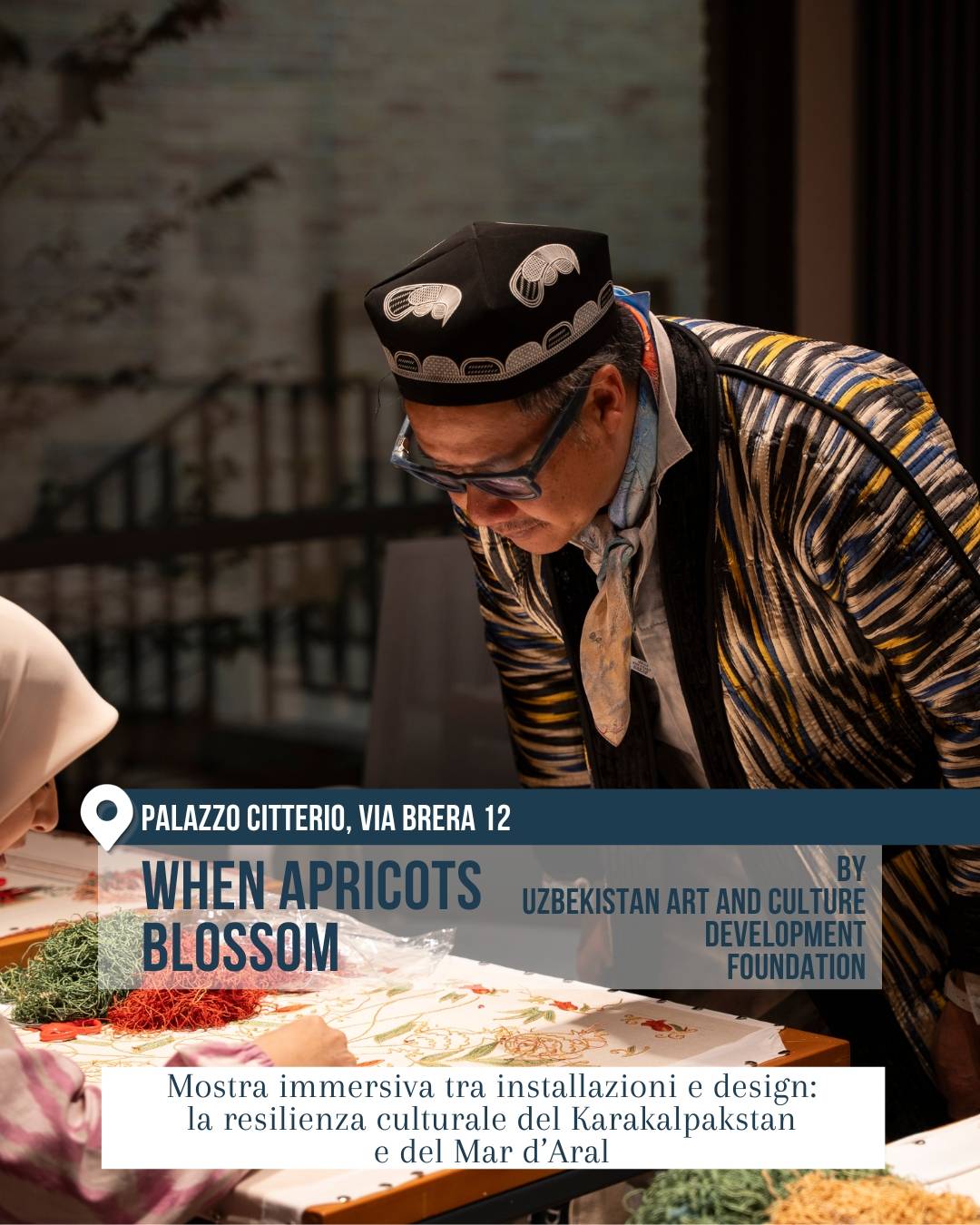 Fuorisalone 2026, Brera Design District: installazione “When Apricots Blossom” a Palazzo Citterio, via Brera 12, firmata Uzbekistan Art and Culture Development Foundation. Una persona osserva un tavolo con ricami, fili colorati e lavorazioni tessili. Mostra immersiva sul design e sulla resilienza culturale del Karakalpakstan e del Mar d’Aral.