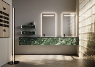 Ideagroup rivista l’iconica collezione Cubik. Ideato nel 2012 da Riccardo Gava, il mobile si caratterizza per i bordi inclinati a 45° dei cassetti e delle ante privi di maniglie esterne. Oggi si aggiungono alla collezione nuovi elementi come il modulo alto 48,5 cm con gola centrale rispetto ai due cassetti e il modulo sospeso alto 60,5 cm. Sono stati introdotti basi e pensili a giorno con il caratteristico bordo a 45°. Anche la gamma delle finiture si è arricchita di materiali naturali pregiati, come il Rovere Caffè e il Rovere Termo, lavorati sartorialmente mantenendo la venatura in “biglia” sui frontali e sui fianchi terminali. Vi sono anche nuove finiture in laminato Unicolor HPL “effetto marmo” – Verde Dolomite, Grigio Yule, Rosso Maya, Bianco Olimpo – e le tinte unite “effetto polvere”, Scintilla, Firmamento, Lampo, Bagliore, Meteora. I frontali con telaio in alluminio a 45° sono disponibili in tutti i colori opachi e metalcolor del campionario. Vi è anche la possibilità di mixare i telai colorati con i vetri applicati, in finitura lucida o acidata retro laccati oppure nelle esistenti finiture stop-sol e acidato grigio trasparente. Per quanto riguarda i vetri vi è anche una proposta decò: il vetro “Flutes” con lavorazione cannettata tridimensionale, declinabile in finitura acidata in tutti i colori del campionario Ideagroup. In foto Cubik in estetica Verde Dolomite. www.ideagroup.it  – Fuorisalone, Showroom Spazio Milano, Via Manzoni 43, Milano