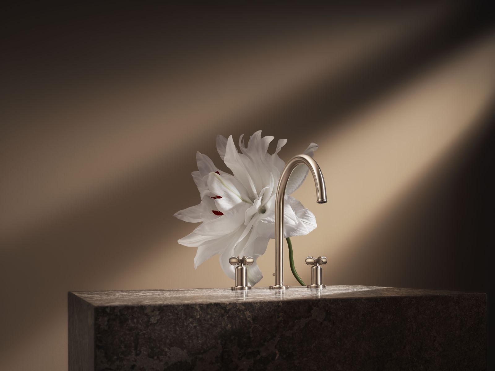 AXOR presenta Archivio, la nuova collezione di miscelatori bagno firmata Barber Osgerby che valorizza forme iconiche e dettagli classici reinterpretati in chiave moderna. Dal lavabo alla vasca, fino agli spazi doccia: il filo rosso è il codice estetico. Le maniglie a croce con inserti bianchi rileggono con sensibilità moderna i tradizionali indicatori caldo/freddo, mentre bocche sinuose, basi a campana, leve slanciate e dettagli scultorei testimoniano la cura riservata a ogni dettaglio. In foto il miscelatore a tre fori, con bocca sinuosa e maniglie a croce, che racchiude in sé l’identità di tutta la collezione. www.axor-design.com/it – Salone del Mobile 2026, padiglione 6, Stand A35.