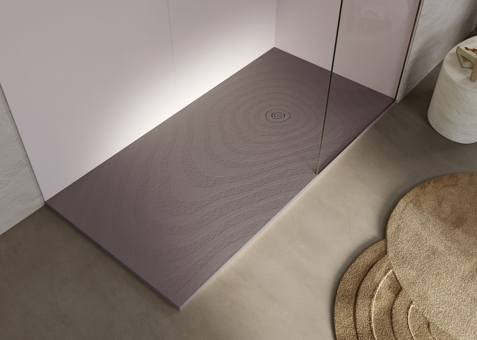 La texture “ondulata” del piatto doccia Natur Wave Forest di Acquabella ricorda
delicate increspature sabbiose che si estendono dalla griglia di drenaggio
circolare, diventando sempre più ampie e ricoprendo l’intera superficie del piatto.
È realizzato, come tutti i piatti doccia dell’azienda, in Akron®, materiale senza silice
brevettato Acquabella. Akron® unisce le qualità del poliuretano alle cariche minerali ed è
trattato su tutta la superficie con un rivestimento, anch’esso in poliuretano. È un materiale igienico, resistente a urti e shock termici e finiture ad alta definizione. www.acquabella.com – Salone del Mobile 2026, padiglione 10, Stand di Calibe A03.