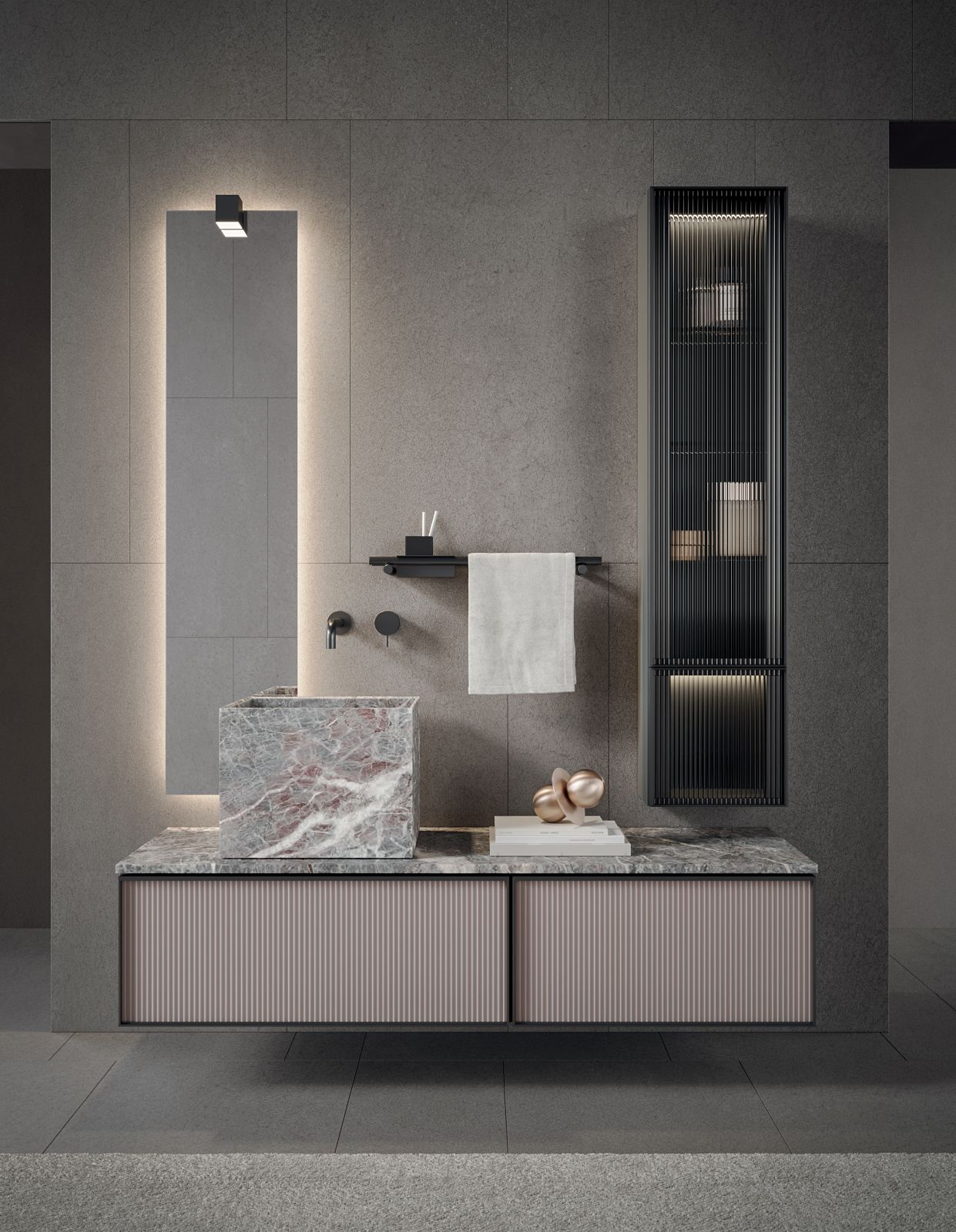 Protagoniste della composizione Quari_Fiore di Pesco di Novello con design Stefano Cavazzana sono le nuance cipria e grigio del marmo Fiore di Pesco Carnico utilizzato per il top e il lavabo monolitico a pianta quadrata. Con orientamento verticale, accosta alla pietra il vetro, quest’ultimo lavorato con finitura cannettata per cassettoni e colonne. Il contrasto tra la solidità scultorea della pietra e la leggerezza delle superfici vetrate genera un equilibrio sobrio e raffinato. La colonna ha anta in alluminio nero e vetro trasparente Fumé Cannettato. Misura L 160 x P 51 cm. www.novello.it  – Salone del Mobile 2026, padiglione 6, Stand C24.