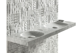 Progettato da Martinelli Venezia per Lithea il sistema-lavabo a mensola Sorgente è una micro-architettura che riporta le tracce dei paesaggi su superfici modellate da cavità, curve e rilievi. È composto da due moduli distinti in marmo Bianco Carrara. Ciascun modulo è caratterizzato da una specifica composizione di vasche scavate, elementi convessi e mini-contenitori incassati: ai lavabi si affiancano piccole sfere emergenti dalla materia, che funzionano come piani di appoggio, mentre le ciotole concave possono essere utilizzate per oggetti e accessori. I due moduli possono essere accostati tra loro, alternati, replicati oppure utilizzati singolarmente. La dimensione longitudinale corrisponde ai moduli di diverse pareti Lithea così il sistema-lavabo si allinea ai rivestimenti. Il Modulo A misura L 1,12 x P 52 x H 8 cm, quello B L 80 x P 52 x H 8 cm. Foto: NinoBartuccio. www.lithea.it – Salone del Mobile 2026, padiglione 18, Stand B08.