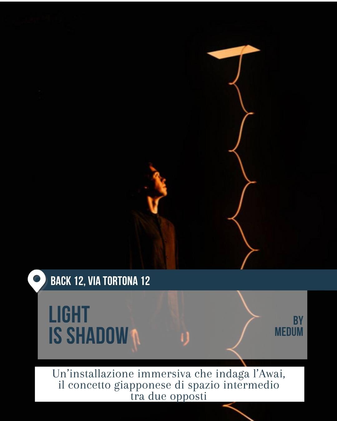 Installazione “Light is Shadow” di MEDUM al Back 12, via Tortona 12, durante la Milano Design Week 2026. Scena buia con figura umana illuminata di profilo mentre osserva una sottile linea luminosa verticale dal disegno organico. L’opera indaga il concetto giapponese di spazio intermedio tra due opposti, con un’atmosfera contemplativa e immersiva.