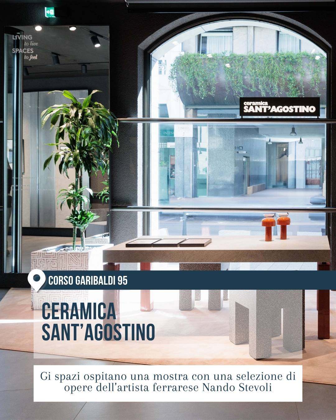 Ceramica Sant’Agostino in corso Garibaldi 95 a Milano durante il Fuorisalone 2026. L’immagine mostra uno showroom luminoso con grande vetrata ad arco, tavolo espositivo, pianta ornamentale e oggetti di design, allestito per ospitare una mostra con opere dell’artista Nando Stevoli.