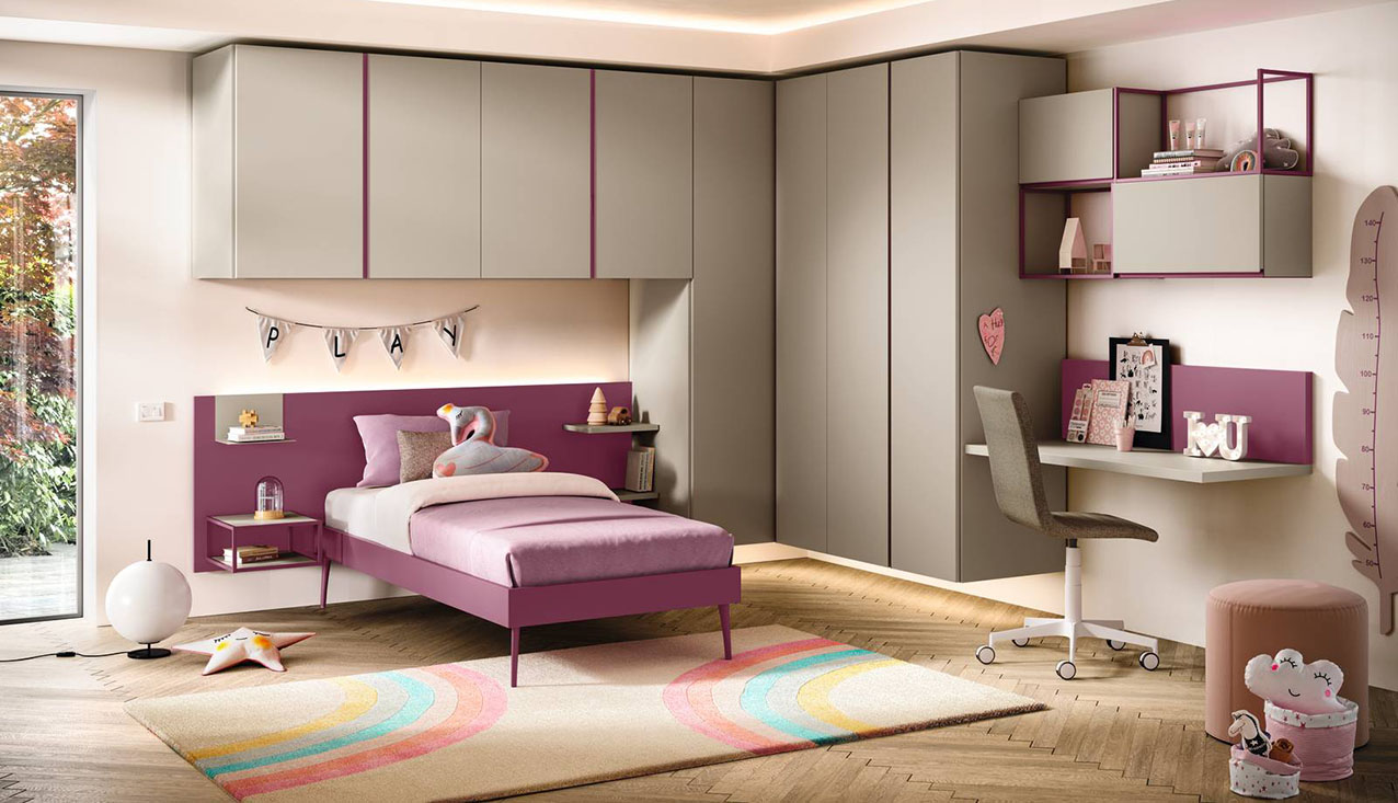 L'armadio a ponte ad angolo sospeso Fly, in nobilitato color Tortora, è il protagonista indiscusso della cameretta K116 della linea Kids Collection di Moretti Compact: libera lo spazio a terra e alleggerisce l'intero ambiente. Il design moderno è sottolineato dalle maniglie a gola laccate a contrasto color lampone. Il vano sottoponte viene valorizzato dal pannello Wally laccato lampone, che integra mensole e comodino sospeso Air Frame, creando una composizione calibrata tra colore, volume e funzionalità. L’illuminazione LED, attivabile con telecomando, trasforma lo spazio in un ambiente intimo e accogliente. https://www.moretticompact.it - Fuorisalone, Moretti Compact Home – Via Edmondo De Amicis 23, Milano.
