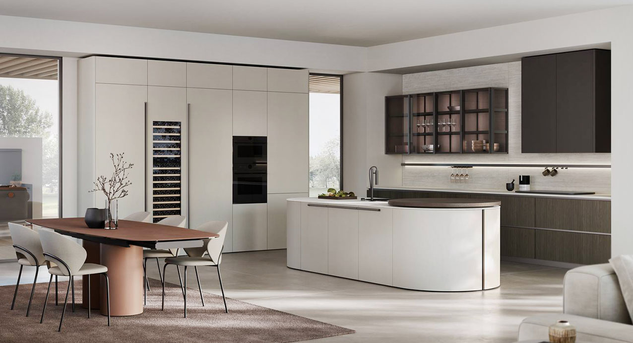 Nasce dall’incontro tra Aliant e Color Trend di Stosa la composizione che accosta finiture calde e profonde come Rovere Cacao, Grafite e Termocotto Onda alla superficie dell’HPL Travertino:  le forme essenziali mettono in evidenza l'espressività cromatica. L'isola centrale è caratterizzata da basi terminali curve e dall'innovativo piano snack rotante. https://www.stosacucine.com - EuroCucina 2026, padiglione 04, Stand C02,D02,D01.