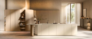 Fa parte del nuovo progetto Flair di Scavolini la cucina con una linea morbida sottolineata dalla presenza di terminali arrotondati. La grande isola, con il piano Vitium Tecnology con texture Super Beige, è dotata di un terminale concavo pensato per “abbracciare” elementi funzionali come il sostegno del piano colazione. Le superfici, laccate opache, nella luminosa colorazione Panna Porcellana sono accostate a quelle in impiallacciato Rovere Emmer delle colonne e del sostegno del piano colazione. https://www.scavolini.com/it - EuroCucina 2026, padiglione 04, Stand C10.