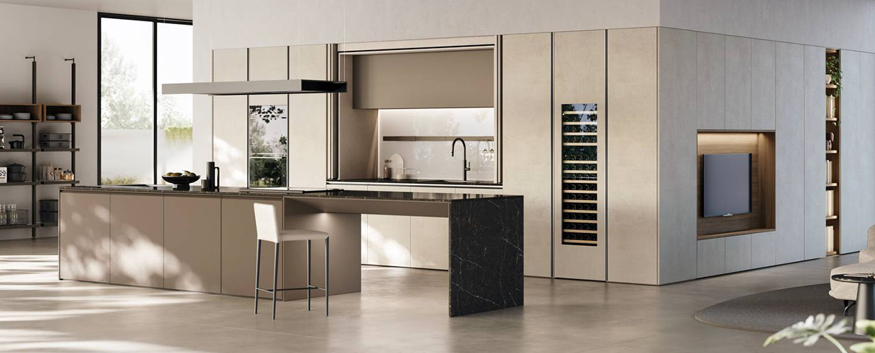 Un sistema progettuale continuo per la cucina Metropolis di Stosa disponibile nella nuova palette Argilla Beige, Noce Mud e Pet Caffè. É caratterizzata dalla presenza di una serie di colonne con ante a scomparsa e schienali in vetro retroilluminati dotati di accessori magnetici. Un ampio bancone, gli elementi a giorno con modulo TV e la nuova libreria palo Hide, attrezzata con soluzioni dedicate per la cucina, completano il modello. https://www.stosacucine.com - EuroCucina 2026, padiglione 04, Stand C02,D02,D01.