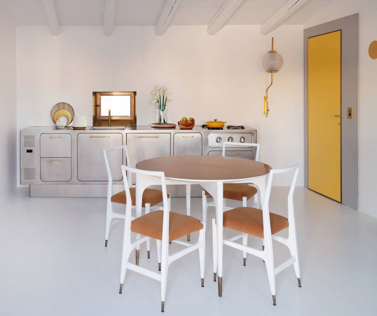 Ha una forma scultorea la cucina Ego di Abimis che spicca sulla parete bianca come una scultura grazie anche all'assenza dei pensili. È interamente prodotta in acciaio AISI 304 e realizzata su misura; la finitura orbitata a mano, ‘calda’ e opaca, permette di ridurre la visibilità di graffi e impronte. Le ante raggiate a filo battente e integrate nella struttura, le cerniere cardine invisibili, le maniglie ergonomiche nella finitura ottone, lo zoccolo rientrato per accedere comodamente all’intera profondità dello spazio di lavoro, il piano privo di fughe su cui convivono la zona cottura e lavaggio la rendono altamente performante e affascinante dal punto di vista estetico. Prezzo su richiesta. https://abimis.com