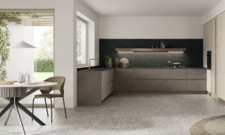 Fa parte della collezione Infinity di Stosa la composizione a golfo che punta sull'eleganza grazie anche all' assenza dei pensili e alla presenza di un alto schienale in HPL Oro Nero su cui trova posto la grande cappa Shelf con il frontale personalizzato in bronzo millerighe che riprende le tonalità della gola e dello zoccolo. Le ante delle basi sono in laminato Malta Ombra, mentre quelle delle colonne laterali sono in Pet opaco Cachemere. Prezzo su richiesta. https://www.stosacucine.com