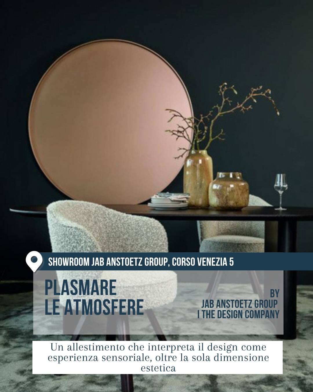 Interno raffinato nello showroom JAB Anstoetz Group, corso Venezia 5, con tavolo scuro, sedute tessili chiare, vasi decorativi e grande pannello circolare rosa cipria. Plasmare le atmosfere interpreta il design come esperienza sensoriale oltre la sola estetica.