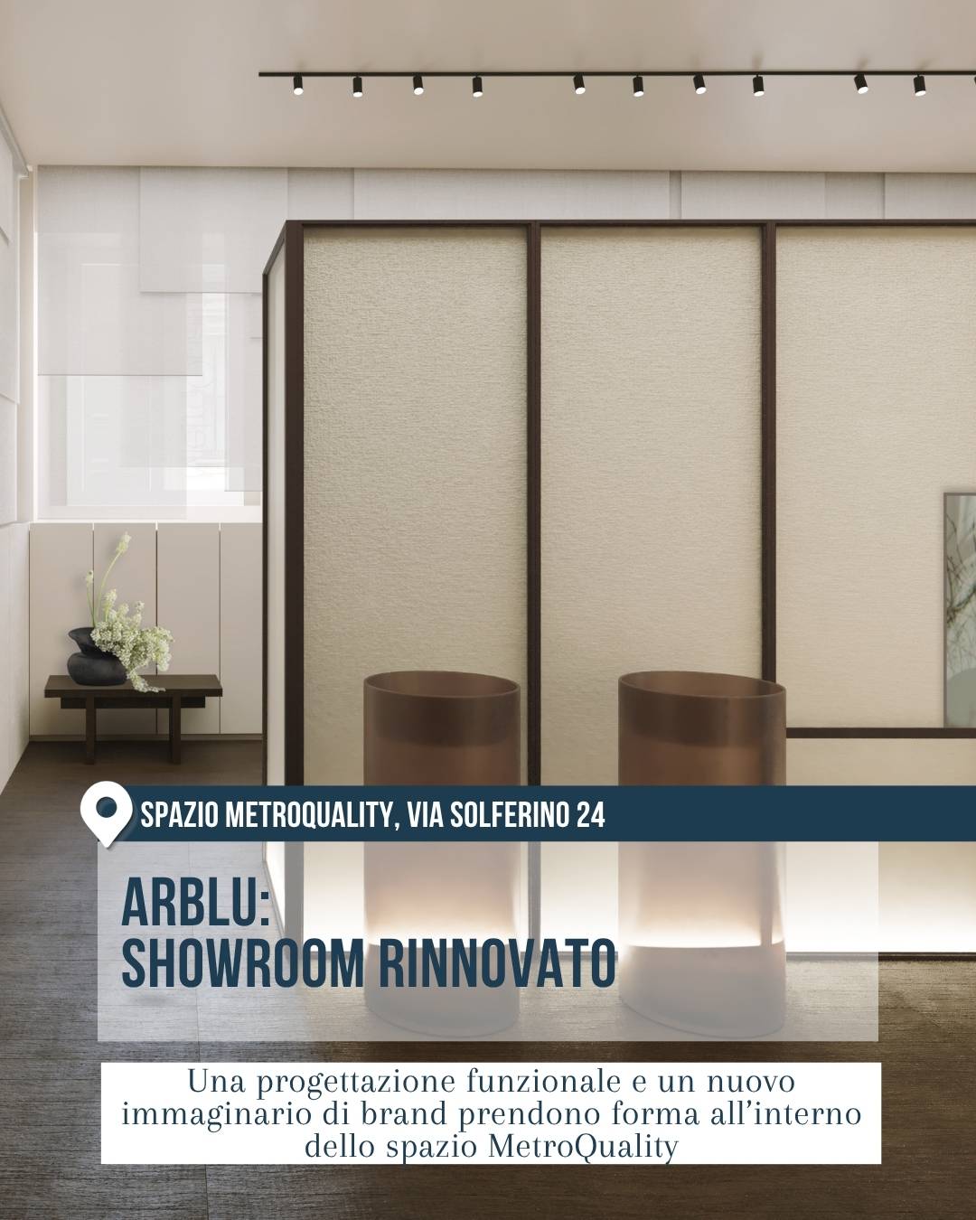Arblu allo Spazio MetroQuality, in via Solferino 24 a Milano, per il Fuorisalone 2026. Interno minimal e architettonico con pareti chiare, pannellature scure, due elementi cilindrici illuminati e luci a binario sul soffitto.