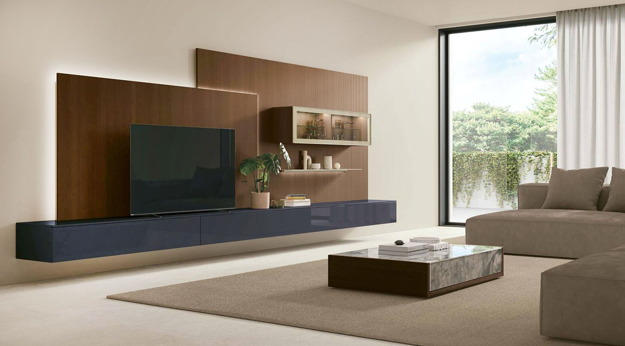 Si trasforma nel cuore della zona giorno il sistema Atlante di Tomasella con volumi e profondità diverse; il pannello retrostante definisce la composizione UNIT_AT145 come una quinta architettonica  su cui si inseriscono la base lineare, il pensile vetrina illuminato e la mensola orizzontale.  https://www.tomasella.it - Salone del mobile 2026, padiglione 07, Stand C02, D02.