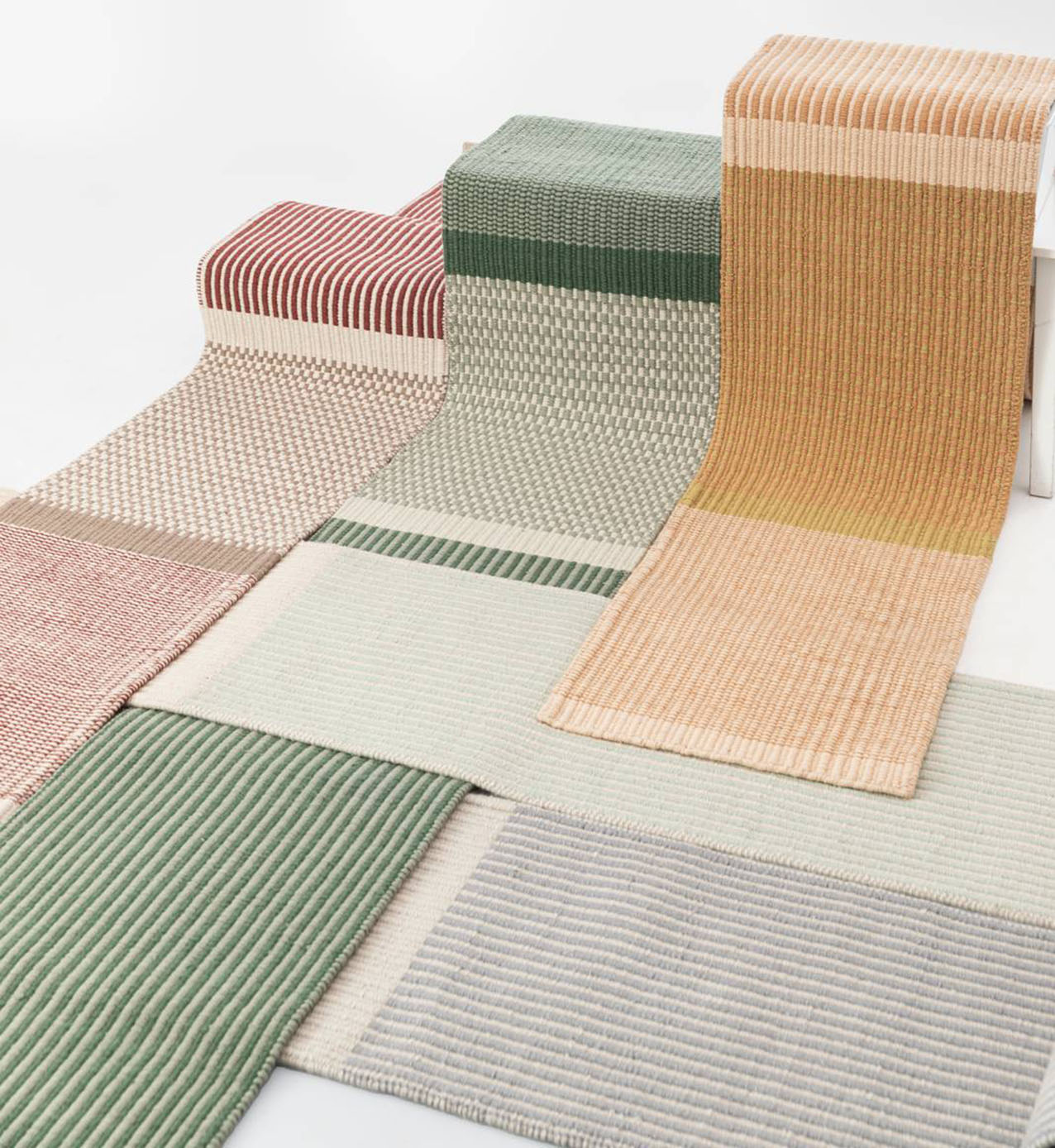 I tappeti indoor Limen di Warli sono caratterizzati dalla combinazione di due colori che danno vita a tre diversi pattern decorativi nelle nuance del verde, del giallo e del rosso. Sono realizzati in lana pregiata per mezzo di una lavorazione che prende avvio dall’utilizzo del telaio manuale tradizionale con tessitura panja, tecnica che impiega un pettine metallico a denti larghi per compattare la trama.  https://www.warli.it - Salone del mobile 2026, padiglione 24, Stand D41.