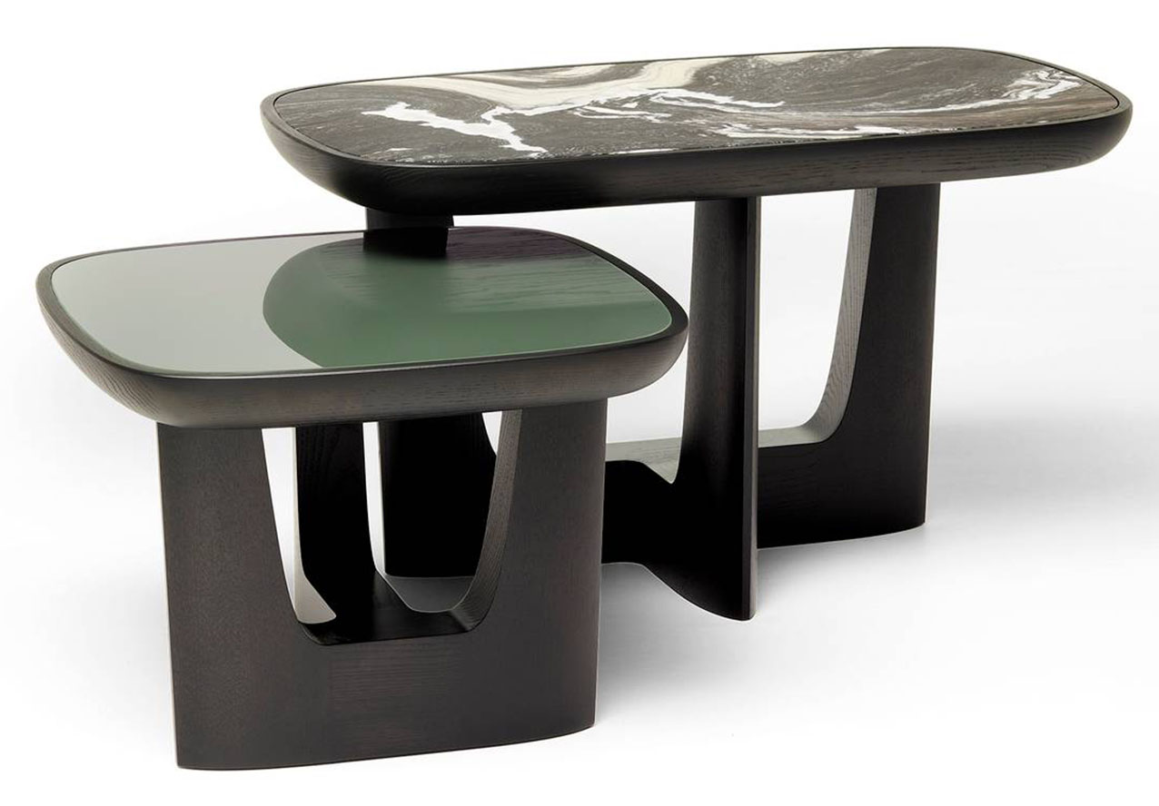 Fa parte della della famiglia Baldwin il tavolino di Ceccotti Collezioni che  ha un volume scultoreo con elementi a sezioni cuneiformi, spigoli vivi e volumi netti. La solida struttura a tre montanti in legno massello di frassino, caratterizzata dalla sovrapposizione di altezze, regge i piani disponibili in materiali diversi: legno, vetro retro-verniciato in diverse colorazioni e marmo. È disponibile in otto modelli diversi. https://www.ceccotticollezioni.it - Fuorisalone, Flagship Store – Via Durini 23, Milano.