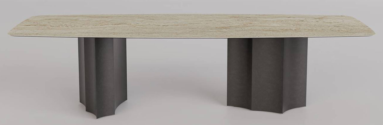 Nel tavolo Iodo di Sovet Italia, design Gianluigi Landoni, i sostegni scultorei sono i protagonisti: sono scavati con profondi “spicchi” che danno vita a una rilettura contemporanea della colonna dorica che ridefinisce il concetto di sostegno. Le sfaccettature che ne derivano non sono mai identiche, ma spezzano la monotonia del metallo, creando una tensione visiva che dialoga con la maestosità minerale del piano. https://www.sovet.com – Salone del Mobile 2026, padiglione 14, Stand B27.