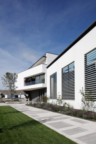 La nuova palazzina Arblu a Fontanafredda: il giardino sensoriale con percorsi in pietra e vegetazione curata, progetto Studio Gottardo e Associati
