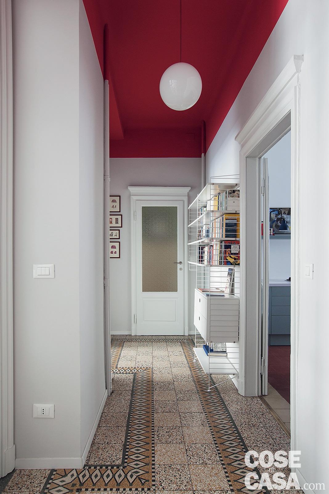 Nell'ingresso e nel corridoio, i pavimenti originali sono in marmette di graniglia degli inizi del secolo scorso. A creare un forte stacco con le tonalità neutre di questo materiale è la tinteggiatura rosso fuoco del soffitto e della fascia alta delle pareti. Progetto arch. Clara Bona, Studio 98, Milano, www.studio98.it - Foto Cristina Galliena Bohman