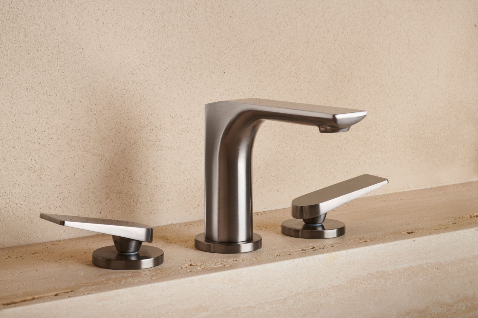 Il design moderno del miscelatore bicomando per lavabo tre fori da piano Blade di Cristina Rubinetterie è definito da tagli netti e precisi che ne scolpiscono la forma. Questi elementi non sono soltanto decorativi, ma contribuiscono alla fusione tra bocca di erogazione e corpo. La leva, posizionata al di sopra del corpo del rubinetto, ricorda una lama sottile. Ha aeratore che limita il flusso a 5,6 litri al minuto. È disponibile nelle finiture: cromo, nero opaco, alux, oro rosa spazzolato PVD, cromo nero lucido e spazzolato, metallic spazzolato e gold brass spazzolato PVD. È alto 13,2 cm. Prezzo nella finitura brushed metallic 755,70 euro. Foto: Paolo Carlini. www.cristinarubinetterie.com