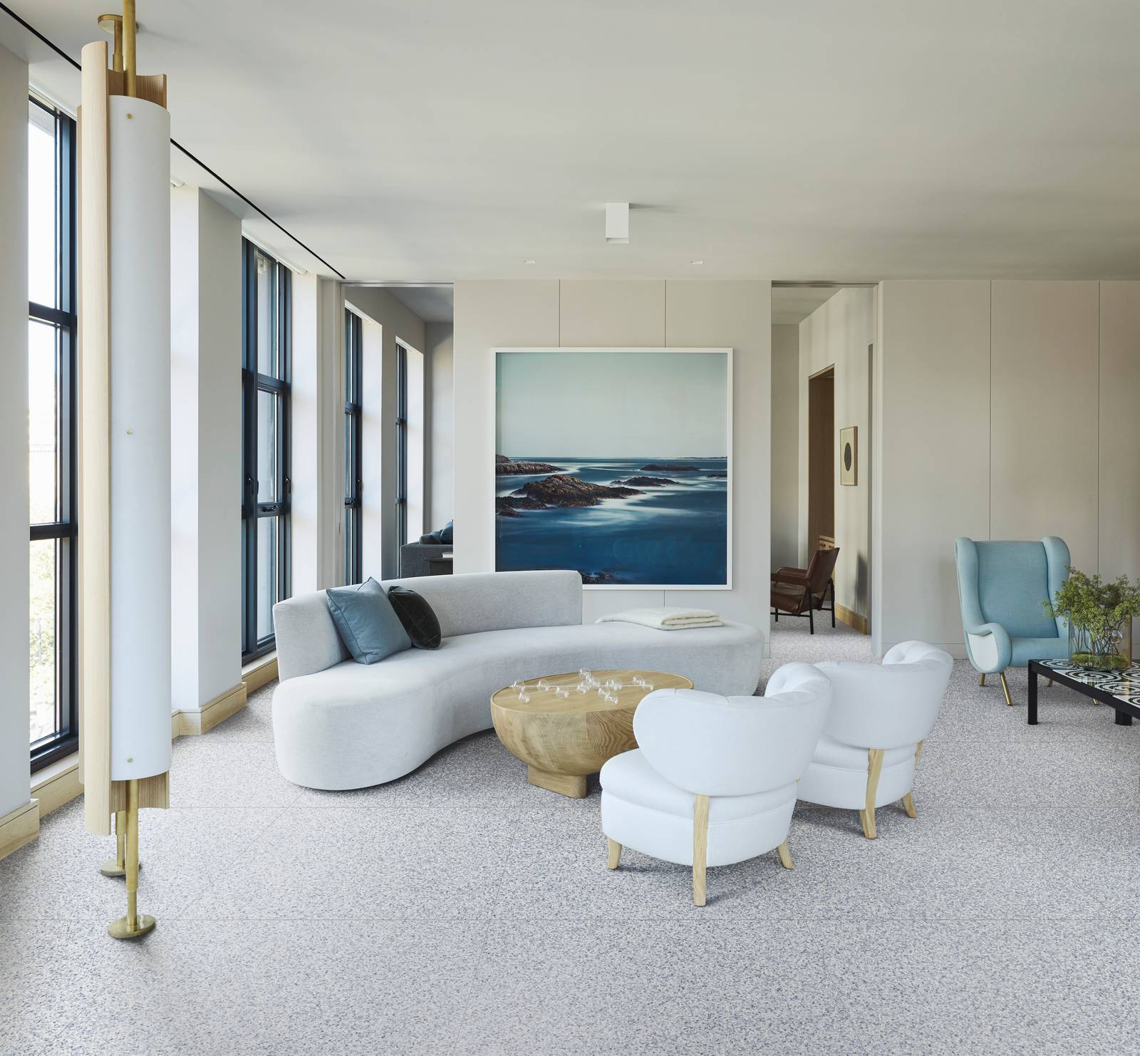 Salotto con divano bianco curvo e pavimento gres Marazzi Frammento