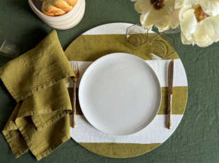 Il copritovaglietta rotondo di Once Milano è realizzato in lino decorato da un motivo a righe cabana verde matcha con effetto dipinto a mano. È rimovibile e necessita di un supporto interno in sughero; inoltre, è disponibile in due formati. Misura Ø 32 cm. Prezzo 56 euro per il set da 2 pezzi.  https://oncemilano.com