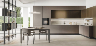 Fa parte della collezione Aliant di Stosa la grande cucina angolare caratterizzata da colori e finiture raffinate: le ante delle basi e delle colonne in vetro opaco Terra e quelle dei pensili in Pet opaco Copper Brown. La pratica barra continua Sign, fissata allo schienale in Neolith Retrostone, è accessoriata con portabicchieri, portarotolo, ganci portaoggetti e illuminazione integrata. La scenografica libreria Vertical Line, con la struttura in metallo e le mensole in vetro fumé, mette in collegamento la zona operativa con il living. Prezzo su richiesta. https://www.stosacucine.com