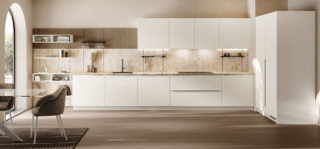 Un ambiente luminoso e fresco con la cucina ad angolo Moda di Scavolini che ha le ante lisce realizzate in PET Bianco Talco abbinate al piano e agli schienali in gres porcellanato Cristallo Macchiavecchia. La boiserie Vertical System in impiallacciato Rovere Dune può essere attrezzata con elementi diversi. Prezzo su richiesta. https://www.scavolini.com