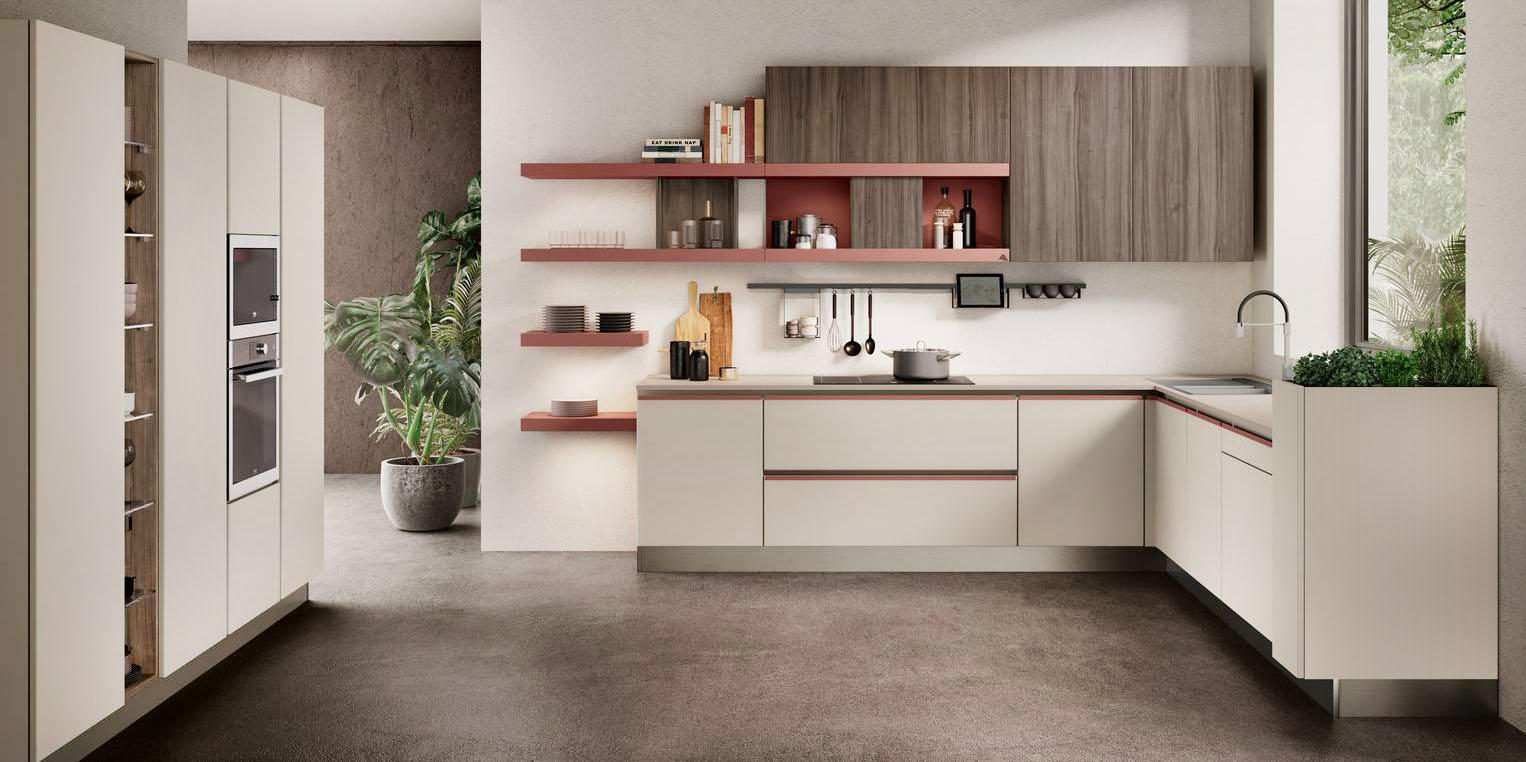 Si sviluppa sotto la finestra la cucina angolare Unica di Lube che è caratterizzata da uno stile pratico e versatile, capace di adattarsi con naturalezza ai diversi spazi dell’abitare. Le ante delle basi e delle colonne in melaminico Dove Grey sono abbinate alle mensole Rosso persia e al top in Fenix chiaro. I pensili nella finitura Phagos vulcano finitura chiselled “spezzano” la composizione. Prezzo su richiesta. https://www.cucinelube.it